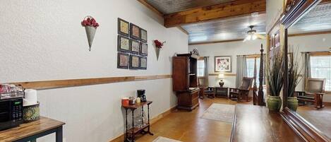 Una habitación amplia con techo de madera, un espejo grande, una zona de comedor y una cocina.