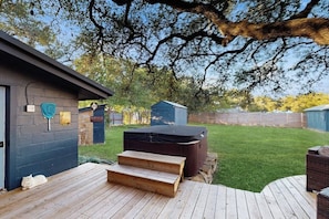 A backyard with a hot tub, a wooden deck, and a covered patio area. - Blue Haus With Hot Tub, Shuffleboard, EV Charger - Walk to Town & Wineries (Johnson City)