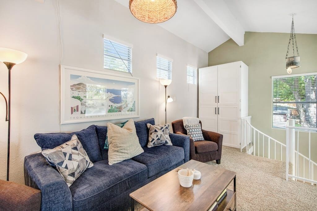 A living room with a blue sofa, a wooden coffee table, a white cabinet, and a framed picture on the wall.
