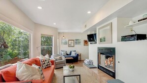 Una sala de estar moderna con chimenea, sofá y mesa de centro.