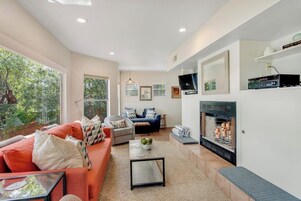 Una sala de estar moderna con chimenea, sofá y mesa de centro.