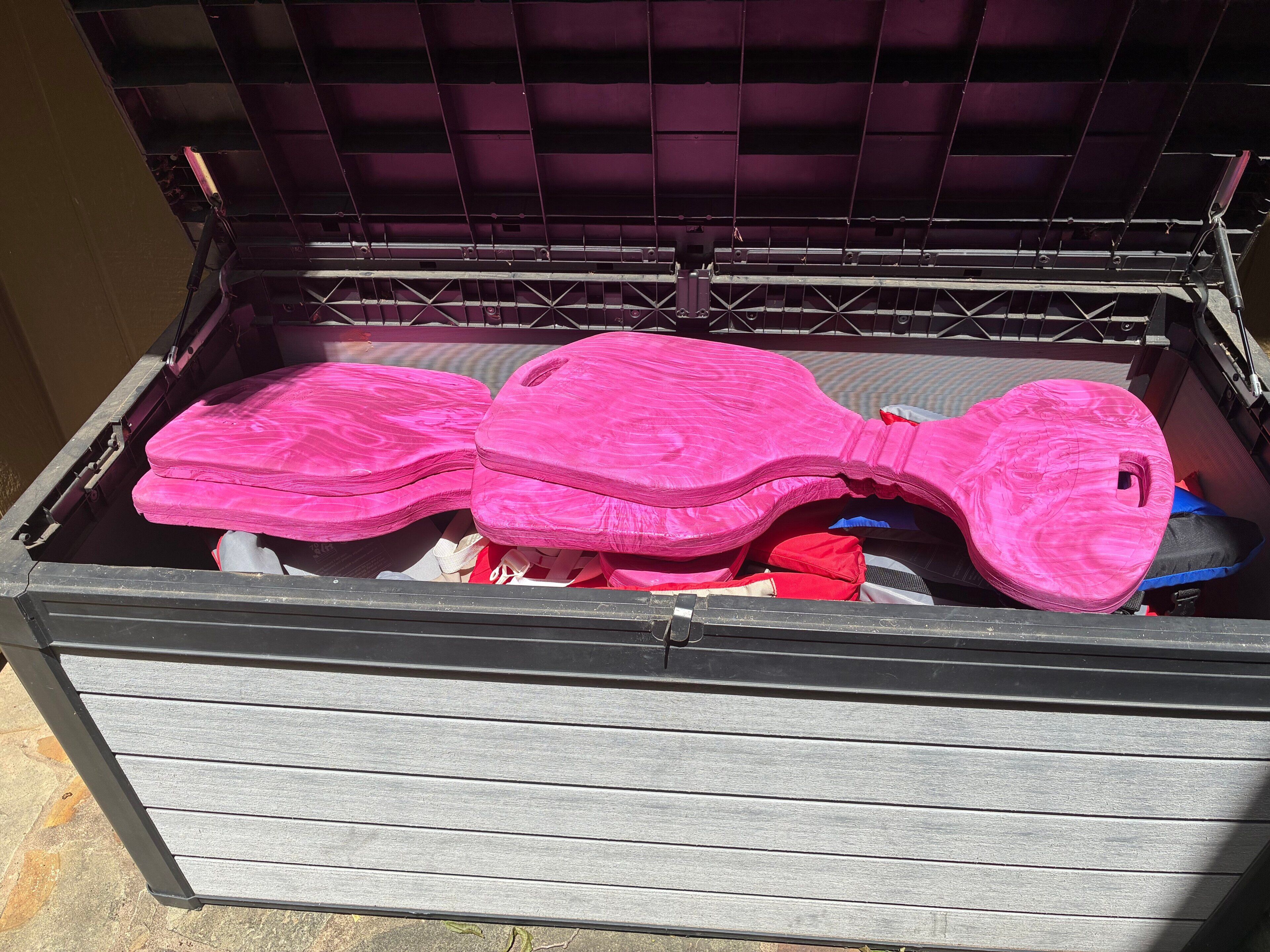 A storage box with pink items inside.