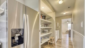 A kitchen with a stainless steel refrigerator, white cabinets, and a wooden stool. - Peaceful Riverfront Home With Enclosed Yard - Walk to the River (Liberty Hill)