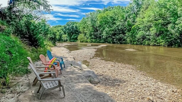 A riverbank with chairs and a clear view of a river. - Peaceful Riverfront Home With Enclosed Yard - Walk to the River (Liberty Hill)