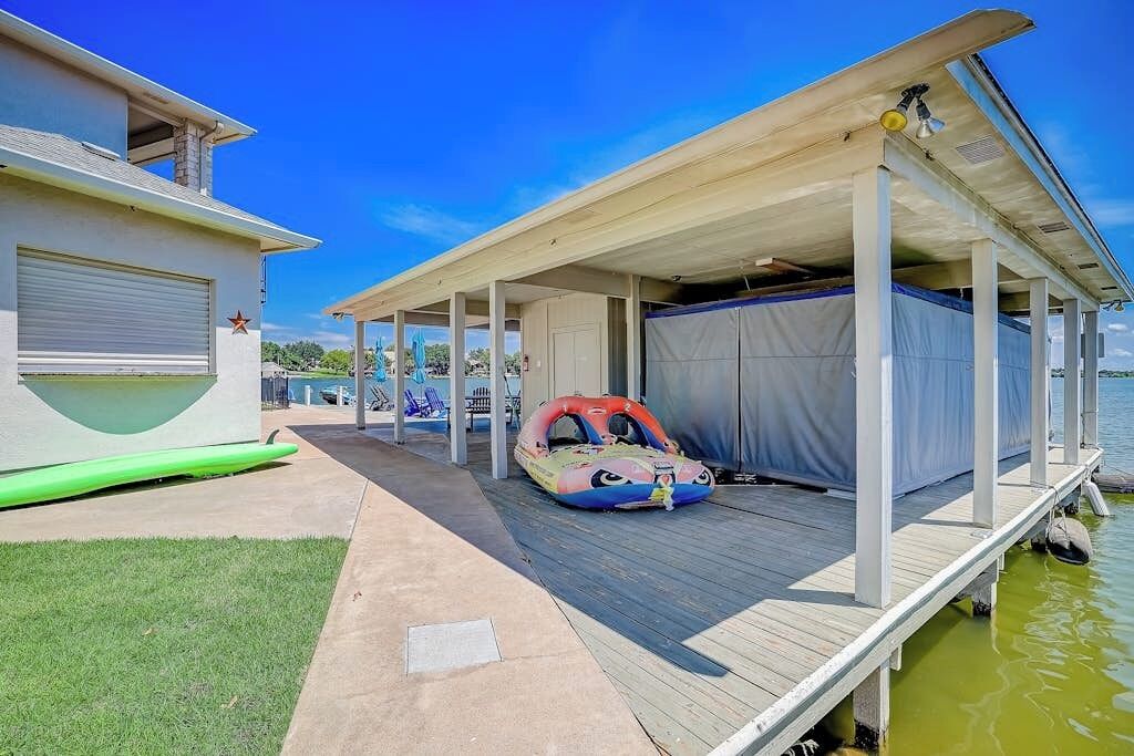 Un espace extérieur abrité comprenant une piscine, un flotteur gonflable et un bâtiment avec un garage.