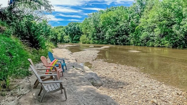 A riverbank with chairs and a clear view of the river. - Cozy Home Near River Access With Firepit & Playground (Liberty Hill)