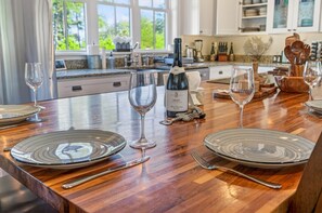 A well-lit kitchen with a wooden countertop, wine glasses, and a bottle of wine. - Driftwood Cove Waterfront/Dock/Game house (Miles)