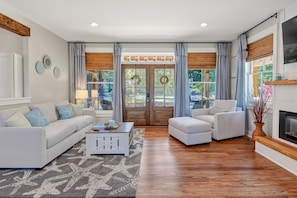 A spacious living room with a white sofa, a white armchair, a coffee table, and a fireplace. - Driftwood Cove Waterfront/Dock/Game house (Miles)