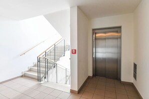 A staircase with a handrail and a fire alarm on the wall. - Central location, 2Bedrooms, Free Parking, Balcony (Prague 5)