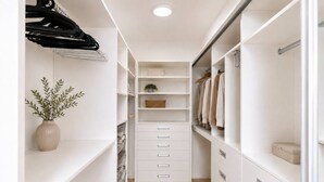A narrow walk-through closet with white shelving, drawers, and hanging space. - Central location, 2Bedrooms, Free Parking, Balcony (Prague 5)