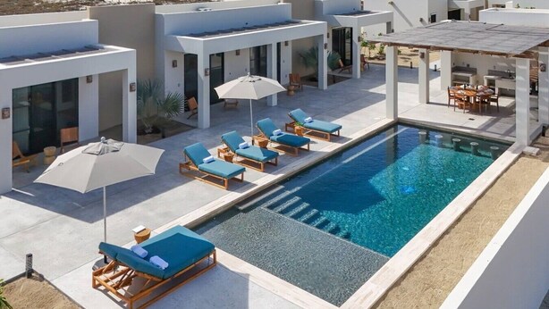 A rooftop pool with lounge chairs and umbrellas, overlooking a beach. - Oceanfront Luxury in East Cape Private Beachfront (Ligth House Point States)