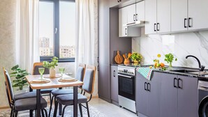 Eine moderne Küche mit grauen Schränken, einem Edelstahlkühlschrank und einem eingebauten Backofen.