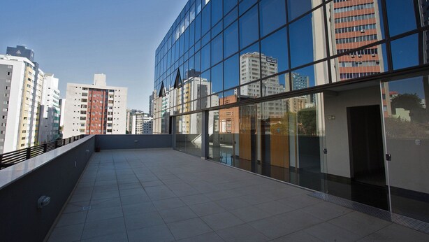 A modern building with large glass windows and a flat roof terrace. - LK Lourdes 11 (Belo Horizonte)
