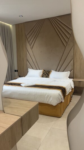 A modern bedroom with a bed, bedside tables, and a unique wall design.