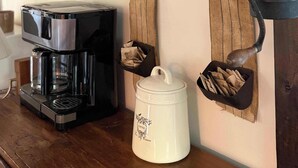 A coffee station with a coffee maker, a coffee pot, and a coffee-themed sign. - Charming Creekside Cottage with Hot tub (Laurelville)