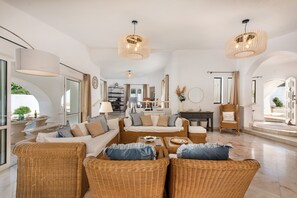 A spacious living area with wicker furniture, a sofa set, and a dining table. - The Beach House - Villa walking to the beach (Albufeira)