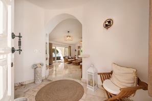A spacious hallway with a wooden chair, a lantern, and a decorative wall light. - The Beach House - Villa walking to the beach (Albufeira)
