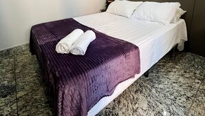 A hotel room with a bed, a painting on the wall, and a marble floor. - LK Lourdes 9 (Belo Horizonte)