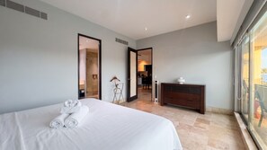 Ein Hotelzimmer mit Bett, Schminktisch, Spiegel und Blick nach draußen.