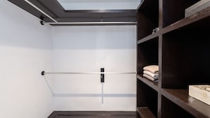 Ein begehbarer Kleiderschrank mit Oberlicht, einer Metallstange und Holzböden.