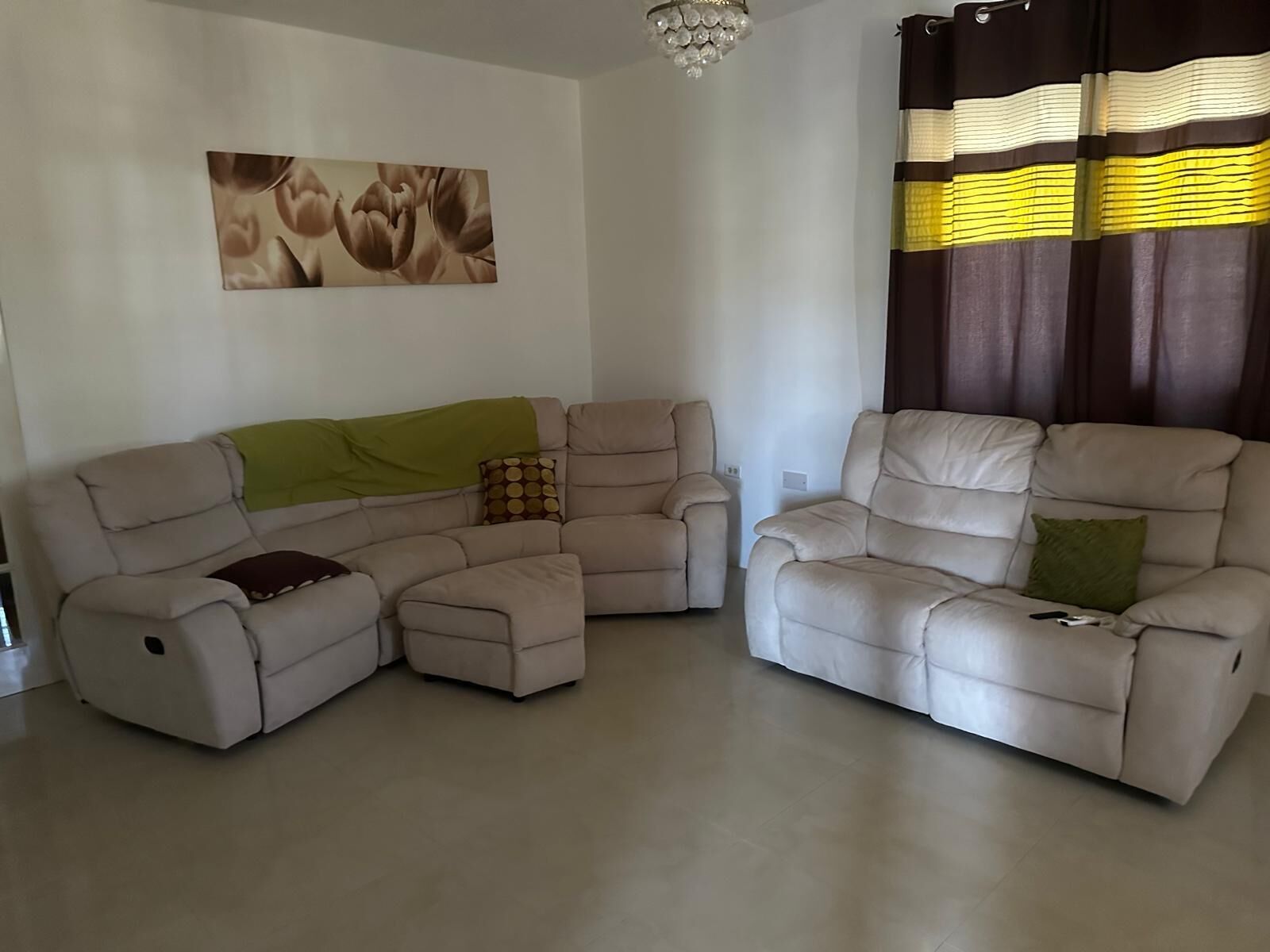 A living room with a sectional sofa, a recliner, and a small table.