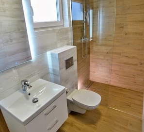 Ein Badezimmer mit Waschbecken, Toilette und Dusche.