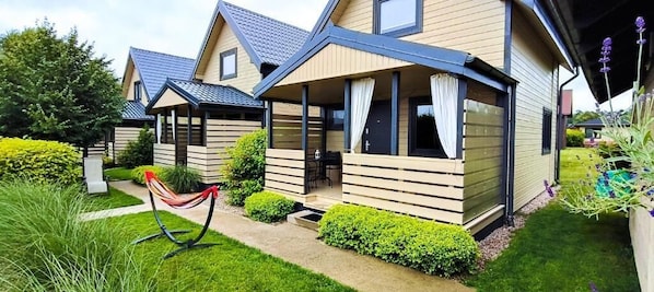 A row of modern, two-story vacation homes with covered porches and a well-maintained garden.