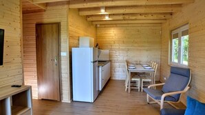 Een houten cabin met een keuken, een eethoek en zitplaatsen.
