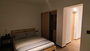 A bedroom with a bed, bedside table, and a wardrobe. - Sevillavenue (Ciudad de México)