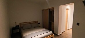 Ein Schlafzimmer mit einem Bett, einem Nachttisch und einem Kleiderschrank.