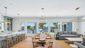 A spacious kitchen with a large island, dining area with a long table, and a living room with a sofa and coffee table. - NEW on Eastern Lake.Private pool,hot tub & dock to fish.Walk/SUP to Beach 400yds (Santa Rosa Beach)