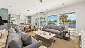 A modern living room with a sofa, coffee table, and dining area. - NEW on Eastern Lake.Private pool,hot tub & dock to fish.Walk/SUP to Beach 400yds (Santa Rosa Beach)