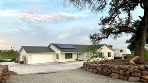 A two-story house with a garage, a covered patio, and a solar panel on the roof. - HandyFarms.com: California Organic Farm Stay on a Red Walnut Orchard Nut Store (Corning)