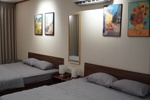 Ein Hotelzimmer mit zwei Betten, einem Spiegel und Bildern an den Wänden.