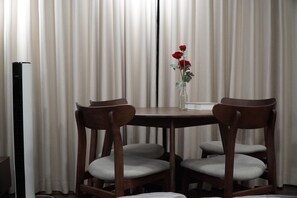 A dining area with a table, two chairs, and a vase with flowers. - Cozy Old Quarter Retreat Walk to Hoan Kiem Lake & Major Landmarks (Hà Nội)