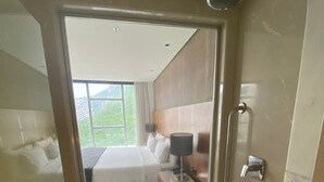 A hotel room with a bed, bedside table, lamp, and a shower. - Private room at Hotel Nacional, Rio de Janeiro, Brazil (Rio de Janeiro)