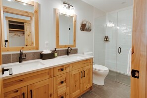 Une salle de bain moderne avec des meubles en bois, un lavabo blanc et des toilettes.
