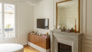 Una habitación con chimenea, televisor montado en la pared y ventana con vista al balcón.