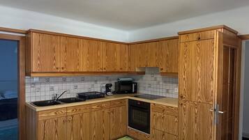 A modern kitchen with wooden cabinets, a microwave, and a built-in oven.