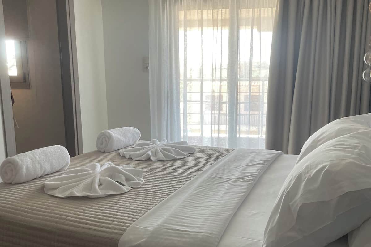 Departamento, balcón, vista parcial al mar | Caja de seguridad en la habitación, cortinas blackout y wifi gratis