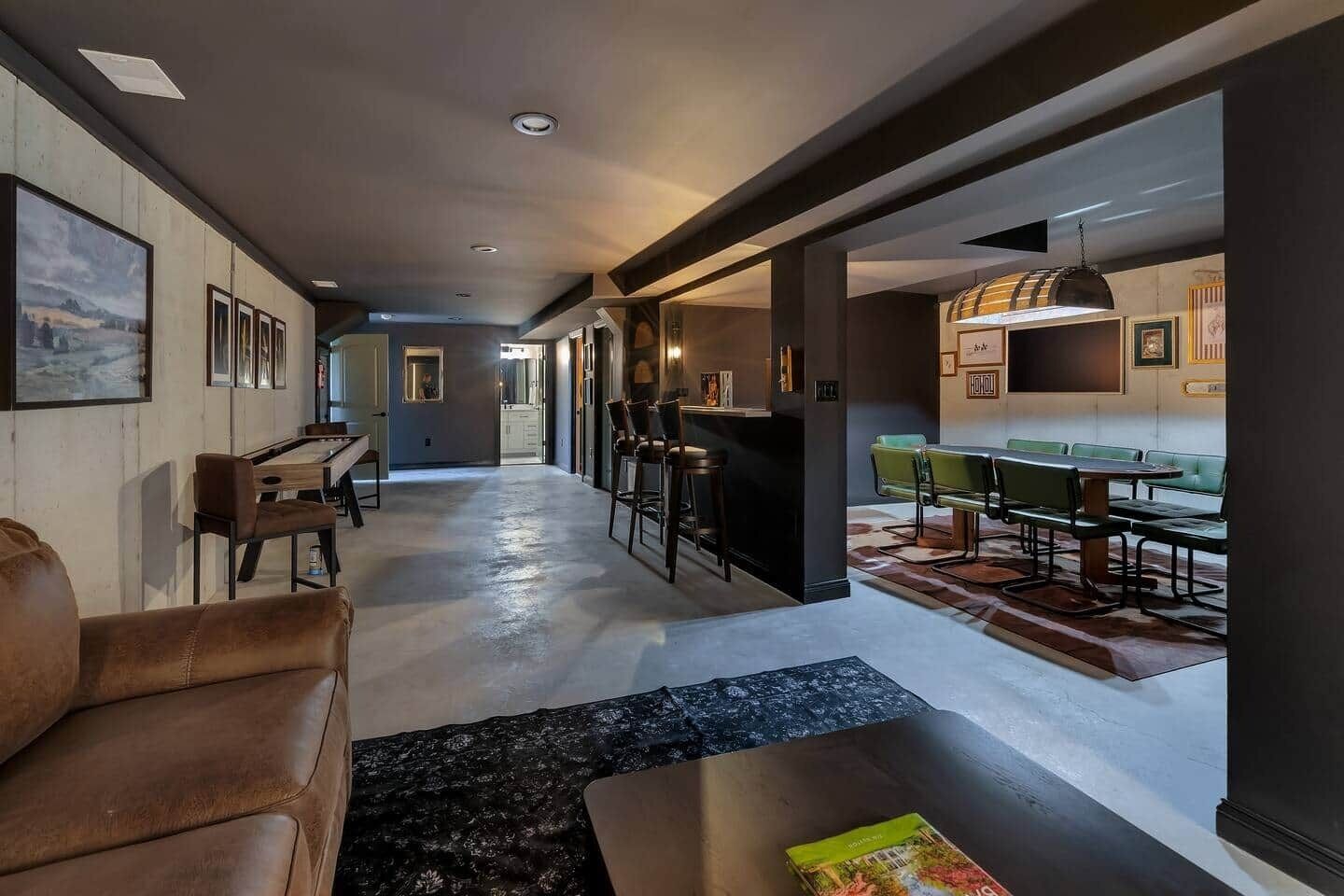 A modern living room with a sofa, a coffee table, and a dining area with a bar.