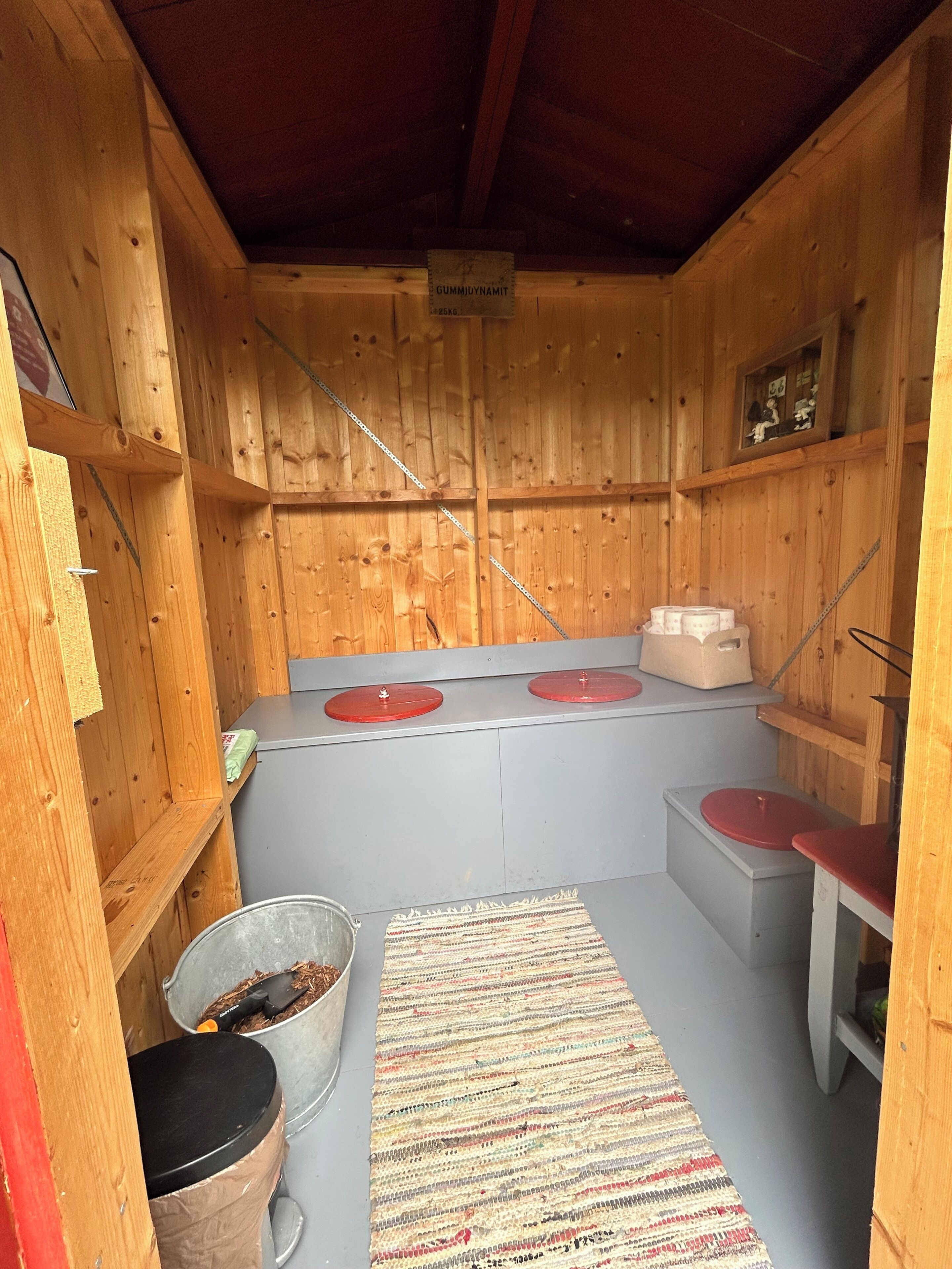 Een houten interieur met een keukenhoek, inclusief een kookplaat, spoelbak en opslagplanken.