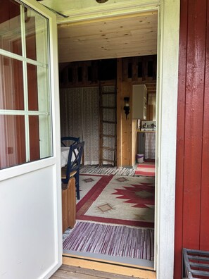 A wooden interior with a door leading to a kitchen area.