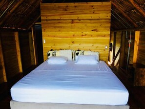 A single bed in a wooden cabin room with a sloped ceiling. - Ecopayara Hotel Puerto Gaitán (Puerto Gaitán)