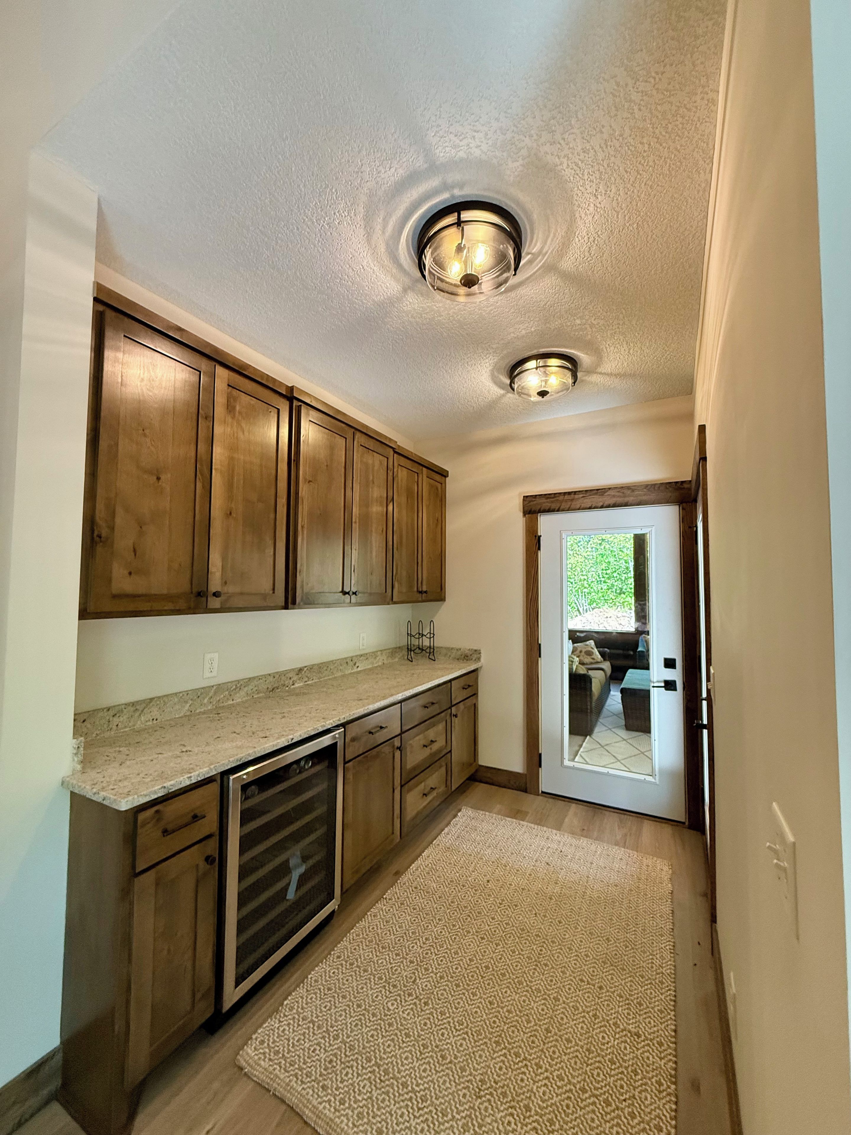 A kitchen with wooden cabinets, a granite countertop, and a built-in oven.