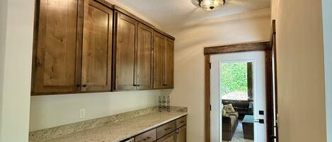 A kitchen with wooden cabinets, a granite countertop, and a built-in oven.