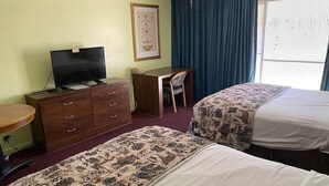 A hotel room with two beds, a desk, a dresser, a television, and a framed picture on the wall. - Budgetel Inn & Suites (Yuma)