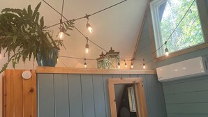 A bathroom with a wooden cabinet, a mirror, and string lights. - A-Frame Cabin -The Get Away #1 (Diana)