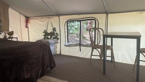 Una tenda arredata con un letto, un tavolo e una sedia.