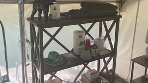Una tenda con uno scaffale che contiene libri, un giocattolo e diversi oggetti.